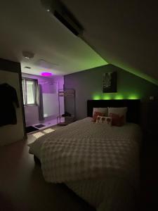 a bedroom with a white bed with green lights at Ô Saphir Spa - Maison N3 in Denain