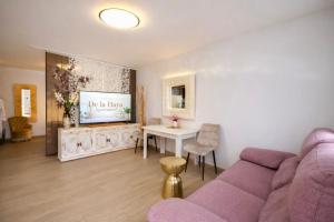 a living room with a purple couch and a table at Apartamentos De la Haya & Suite con Jacuzzi, junto al Teatro Romano in Mérida