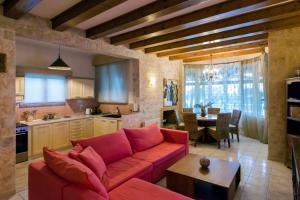 a living room with a red couch and a kitchen at Maxim in Corfu