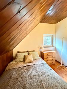 a bedroom with a large bed and a wooden ceiling at Kurort Mirowice-domek w lesie, z balią z jacuzzi i hydromasażem in Mirowice