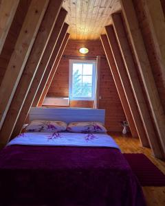 a bed in a wooden room with a window at Sea View Wooden Houses - Resort Sokoli in Lezhë +158 photos
