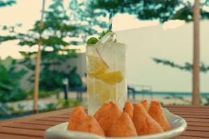 a drink on a table with a plate of food at Clatt Hotel in São João da Boa Vista