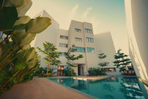a building with a swimming pool in front of a building at Clatt Hotel in São João da Boa Vista