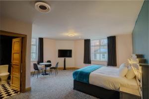 a hotel room with a bed and a desk at The Bath Rooms in Morecambe