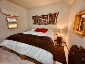 a bedroom with a large bed in a room at Curahuapi Refugio de Montaña in Las Trancas
