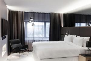 a bedroom with a large white bed and a chair at Radisson Blu Royal Hotel, Helsinki in Helsinki