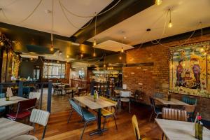 a restaurant with tables and chairs and a brick wall at The Bath Rooms in Morecambe