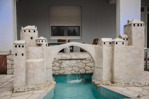 a castle house with a bridge over a pool at Villa Bojcic in Mostar