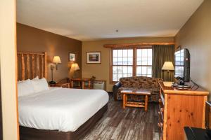 a hotel room with a bed and a desk with a television at Grand Ely Lodge in Ely +34 photos