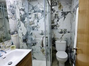 a bathroom with a shower and a toilet and a sink at Entire Apartment near Valencia - 2 Bedrooms & 2 Bathrooms in Paterna +28 photos