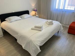 a bedroom with a white bed with towels on it at Santiago Apartment in Caminha