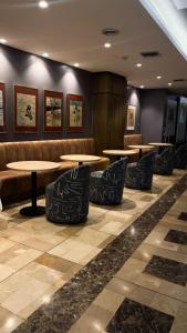 poczekalnia ze stołami i kanapami w obiekcie Hotel Ramada w mieście Guayaquil