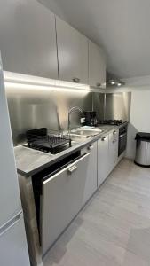 a kitchen with a sink and a stove top oven at Le loft sous les toits in Arles +14 photos