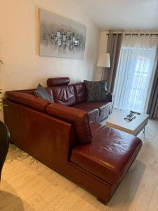 a brown leather couch in a living room at Appartement cosy entièrement équipé in Villeneuve-sur-Lot