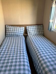 two beds sitting next to each other in a room at TLJ Caravan Hires in Mablethorpe +8 photos