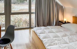 a bedroom with a bed and a chair and a window at Nice Home In Röbel With Sauna in Röbel