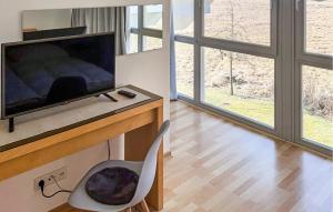 a living room with a television and a chair at Nice Home In Röbel With Sauna in Röbel