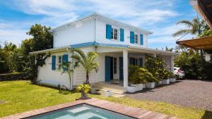a house with a swimming pool in front of it at Villa kréoli avec picine privée et cuisine extérieur pour 8 personnes in Saint-André