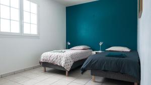 a bedroom with two beds and a green wall at Villa kréoli avec picine privée et cuisine extérieur pour 8 personnes in Saint-André +7 photos