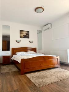 a bedroom with a wooden bed in a room at Casa TeoDora Caciulata in Căciulata