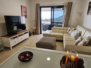 a living room with a couch and a flat screen tv at Terraza del Atlantico 1 + 2 in Barlovento