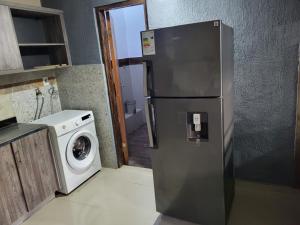 a refrigerator in a kitchen with a washing machine at Complejo Residencial Las Lomitas in San Lorenzo de la Frontera