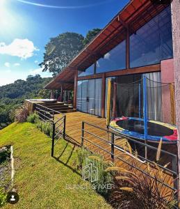 a house with a large deck with a trampoline at Casa 3 Quartos Recanto Buritis in Santa Teresa