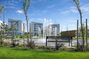 a park with a bench and a fountain at DIAMOND MIRAGE Militari Residence in Chiajna
