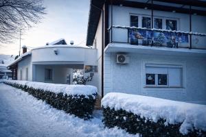 a house covered in snow in front of it at Apartmani Kotor Varoš in Donja Varoš