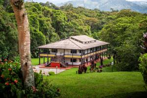 a large house in the middle of a green field at Hotel Guaitipan Ancestral in San Agustín