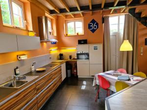 a kitchen with a sink and a table with a dining room at Station Racour 'Magasin de la gare' in Landen