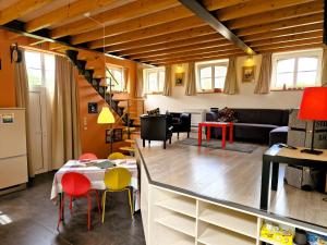 a kitchen and living room with a table and chairs at Station Racour 'Magasin de la gare' in Landen