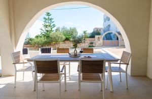 a dining room with an arched window and a table and chairs at Villa Selina 7 - Etheras Properties in Kythira