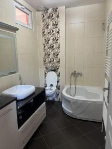 a bathroom with a tub and a sink and a toilet at Prestige Old Town Villa in Sarajevo +25 photos