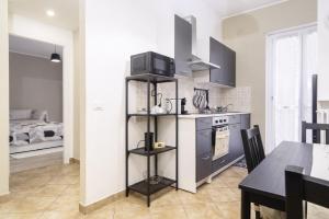 a kitchen with a stove and a dining room at Dimora Stadio Biella in Biella