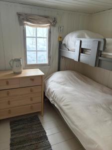 a bedroom with two bunk beds and a dresser and a window at Cosy mountain cabin 875m near Turufjell, ski, fishing, hiking and quiet nature in Flå