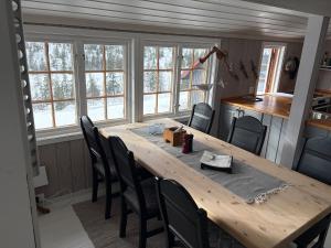 a dining room with a wooden table and chairs at Cosy mountain cabin 875m near Turufjell, ski, fishing, hiking and quiet nature in Flå +50 photos
