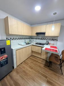 a kitchen with wooden cabinets and a refrigerator at Mini centrica suite privada con todo incluido in Loja