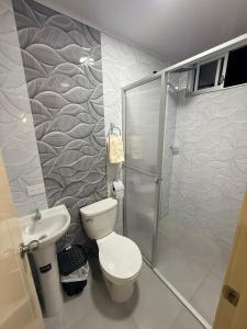 a bathroom with a shower and a toilet and a sink at Mini centrica suite privada con todo incluido in Loja
