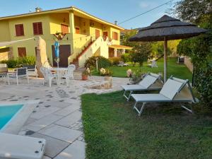 a patio with a table and chairs and an umbrella at Villasulizzu in Budoni
