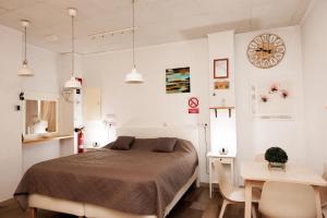 a bedroom with a bed and a table and a clock at Loft Valentia Olta Calpe in Calpe