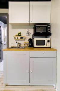 a kitchen with white cabinets and a microwave at The HIDE - Dreamland in Boldeşti-Scăeni +46 photos