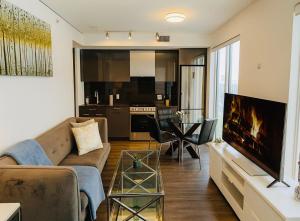a living room with a couch and a tv and a table at Cozy Room & Bath Downtown Toronto in Toronto