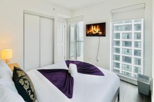a white bedroom with a bed and a window at Cozy Room & Bath Downtown Toronto in Toronto