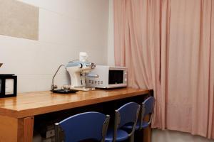 a kitchen with a table with a microwave and blue chairs at Loft Valentia Olta Calpe in Calpe