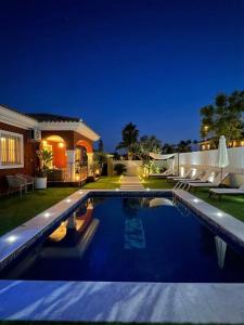 a swimming pool in front of a house at night at Chalet exclusivo bonalba in Alicante
