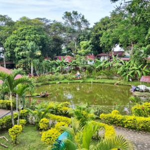 a garden with a pond with people in it at Hotel campestre los gabrieles in Rivera