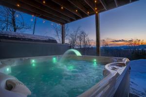 a jacuzzi tub with lights in the snow at Epic Views, 9Mi SR, GameRmTheater, HTub, Sauna in Bethel