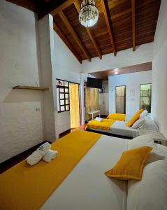 a bedroom with three beds and a chandelier at Hotel campestre los gabrieles in Rivera +58 photos