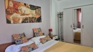 a bedroom with two beds and a painting on the wall at Apartment Trezza in Acitrezza
